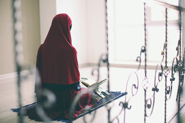 Young Muslim woman praying, indoors
