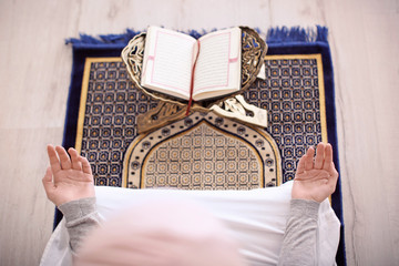 Young Muslim woman praying, indoors
