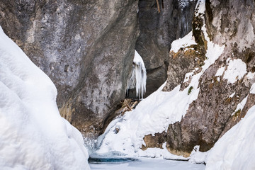 Fototapeta na wymiar Frozen icy waterfall in snow covered gorge Baerenschuetzklamm in winter