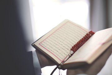 Fototapeta na wymiar Young Muslim man reading Koran, closeup