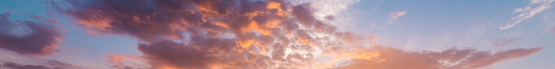 Naklejka na ściany i meble Fiery orange, pink and blue very beautiful sunset sky. Dramatic clouds after rain