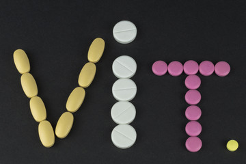 inscription reduction vitamin from tablets on a black background
