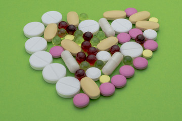 heart of pills on a green background