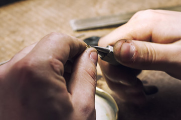 Fototapeta premium jeweler produces gold jewelry in the workshop