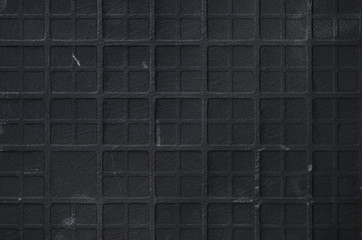 Texture of Ceramic Scratched Tile with Checkered Embossing. Black Scratched Wall Background