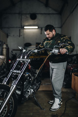 Fototapeta na wymiar Young man doing hard job in car and motorcycle repair shop.