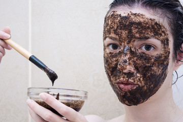 Caucasian model between age 20-29 years using a coffee face scrub for her face and eye bags.