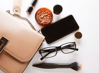 Flat lay of female fashion accessories and pink  handbag on whit