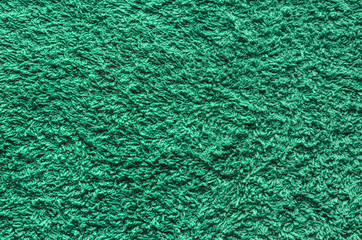 Abstract background of shaggy green carpet pile. Cloth texture with long fibers