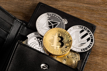 crypto currency coin in leather wallet on wide wood wooden background  bitcoin ethereum litecoin iota ripple