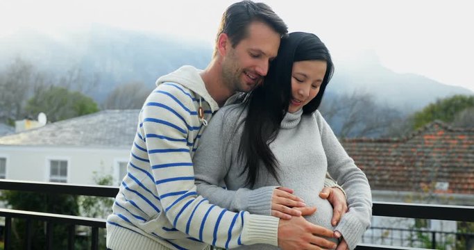 Happy couple feeling the presence of baby in stomach 