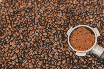 Espresso machine scoop on coffee beans background