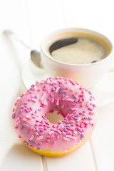 Pink donut and coffee cup.