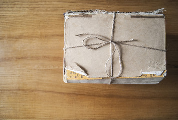  a stack of old books tied with a jute thread on a wooden table