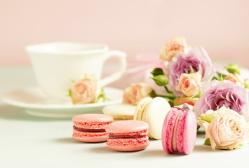 macaroons in pastel colors with flowers on a pale pink background.Holiday background.copy space