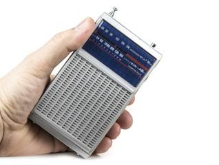 Old and small transistor radio on battery on the white