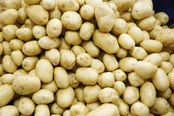 Pile of fresh, raw potatoes, textured background