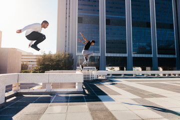 Two men doing parkour in city