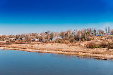 View Of Village On Overgrown Hill Near Yellowed Riverbank, Sunny