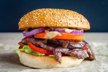 Beef burger with tomato, salad, onion, pepers and cheese