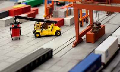 Toy loader carrying a container in a layout of a cargo hub