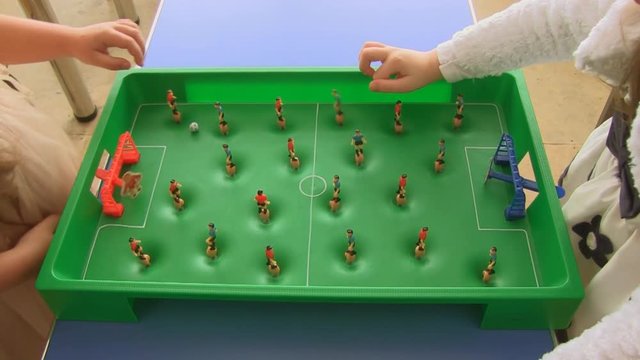 Two girls play a Board game of football. close up