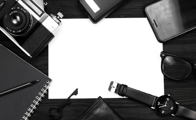 black watch, black pencil, notebook, camera purse and phone on black background