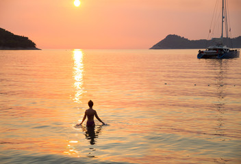 girl swims at sunset