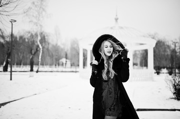 Naklejka premium Elegance blonde girl in fur coat and red evening dress posed at winter snowy day.