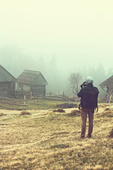 The photographer takes a photo of the landscape in the fog.