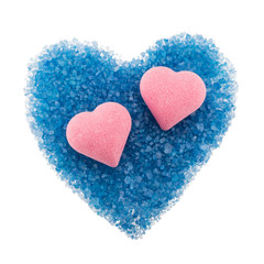 Composition of heart-shaped bath bombs and scattered blue bath salt