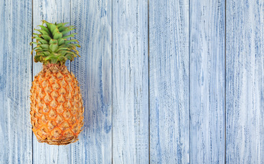 whole pineapple on a light wooden background with copyspace