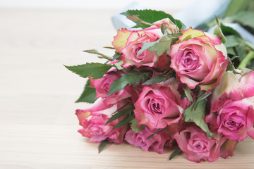 Bunch of beautiful pink roses on wooden background.