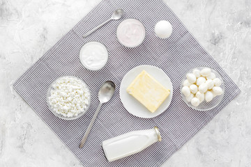 Fresh dairy products. Milk, cottage, cheese, yougurt on grey table with blue tablecloth top view. Monochrome