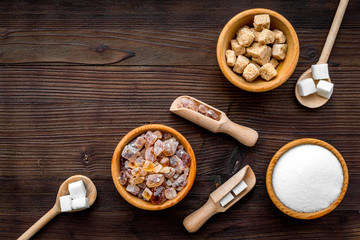 Sugar types. Cane, refind, granulated, cubes, candy sugar. Dark wooden background top view copy space