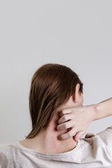 Close up view of woman scratching her neck. 