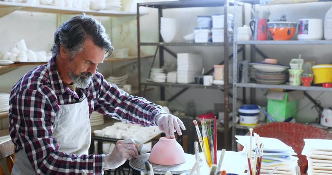 Male potter designing the ceramic bowl 