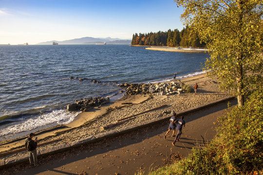People doing sports and relaxing along the seawall in Stanley Park, Vancouver
