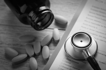 stethoscope and yellow pills with document, concept healthcare