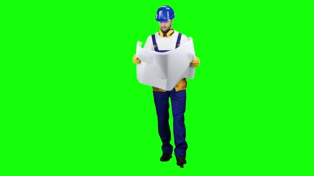 Designer with the drawing in his hands goes on the object and looks around. Green screen