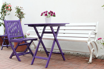 Violet wooden chairs and a table with a bouquet of flowers