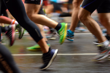 Male and female runner's legs on asphalt. Marathon - Powered by Adobe