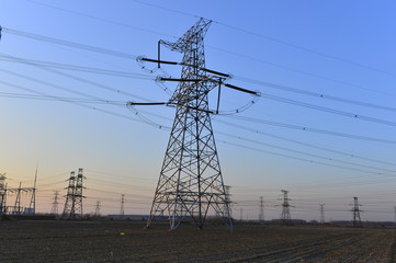 The silhouette of the evening electricity transmission pylon