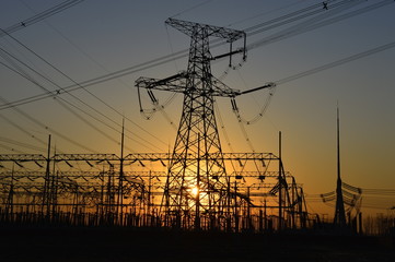 Fototapeta premium The silhouette of the evening electricity transmission pylon