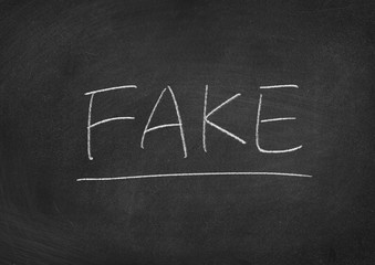 Obraz premium fake concept word on a blackboard background