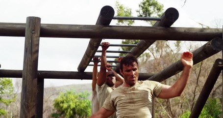 Military soldiers climbing monkey bars - Powered by Adobe