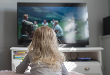 Fototapeta na wymiar Little girl watching a movie on TV