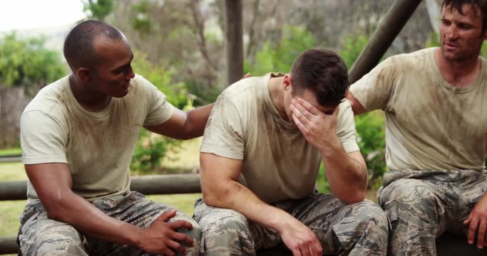 Militray soldiers consoling their teammate at boot camp 