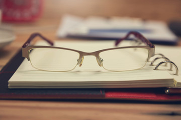 Business and finance concept of office working, Closeup eyeglasses on office desk in working day.