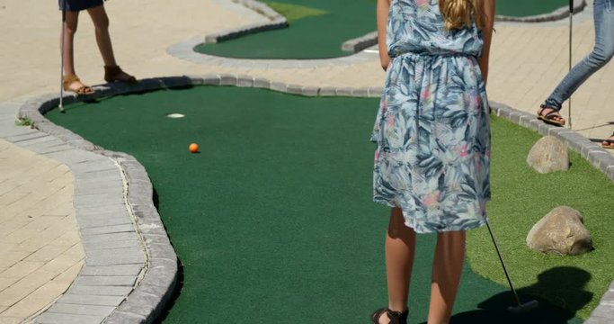 Kids playing miniature golf in the garden 